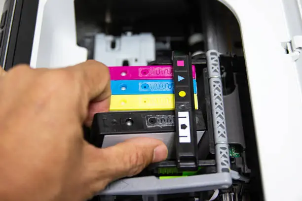 One hand is installing an ink cartridge